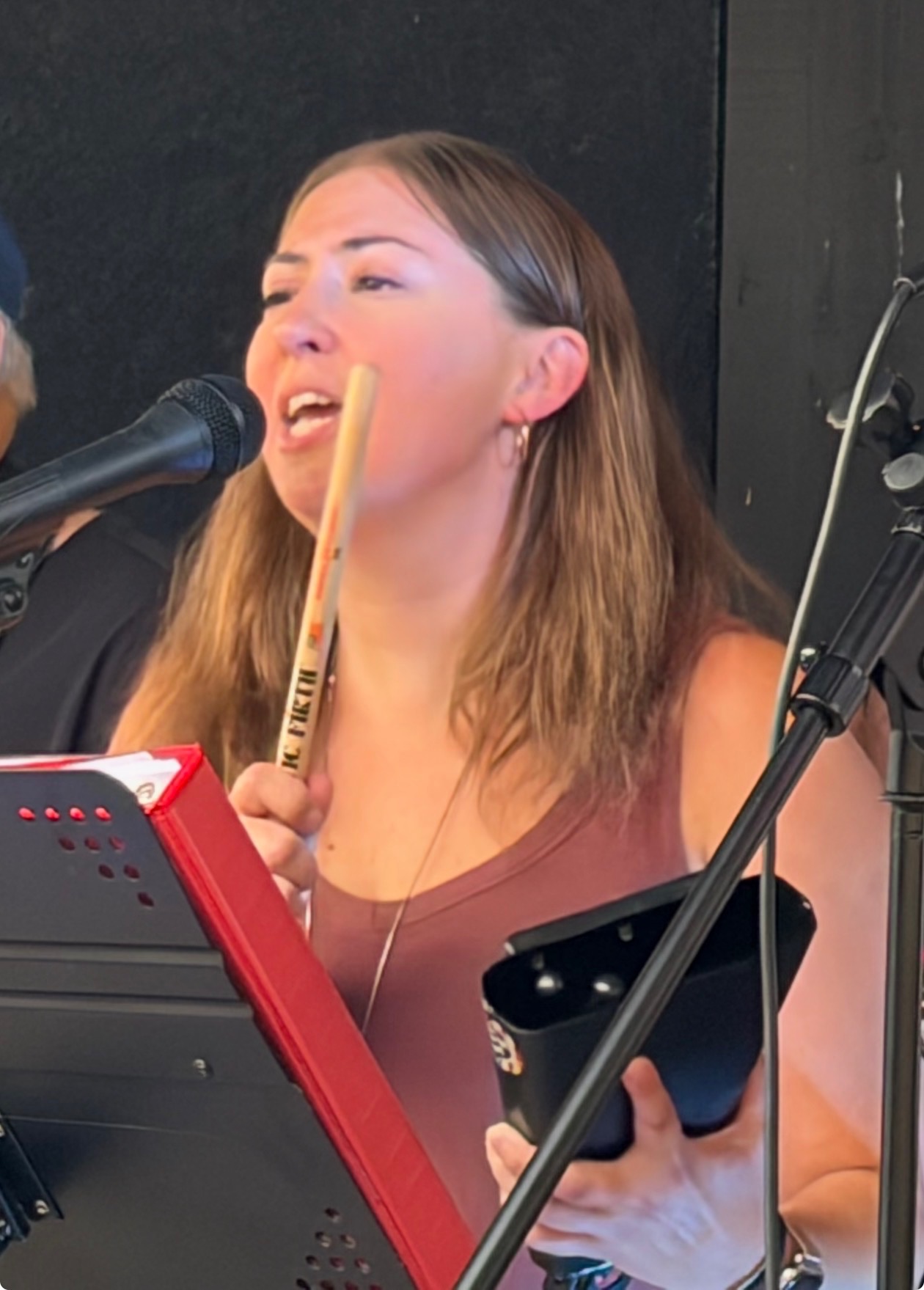 Brittany Hassler singing and playing cowbell